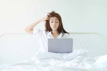 Asian women sitting at home on the couch She is very tired and sleepy.Do not focus on the main object of this image.