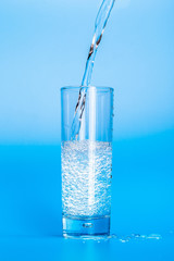 Close up pouring purified fresh drink water from the bottle on table