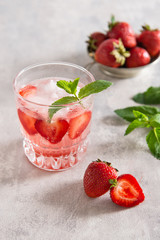 Strawberry lemonade in glass on a grey background. Close up. Refreshing summer drink.