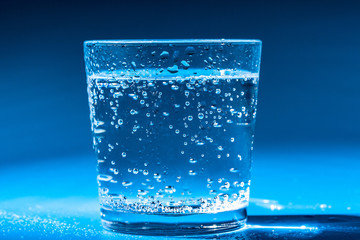 glass of water on a table  on a dark background