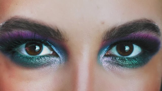 Amazing glance. Close up of caucasian woman eyes in glowing eyeshadows looking at camera. Fashion eyes makeup