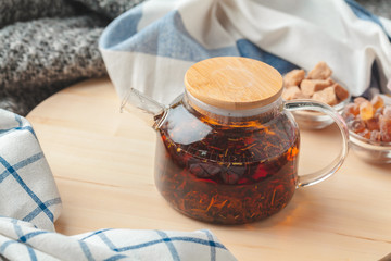 Earl Grey tea in glass tea pot on wood plate close up
