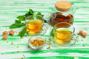 Black tea on green wooden background