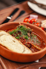 beef cooked with tomato sauce on wood