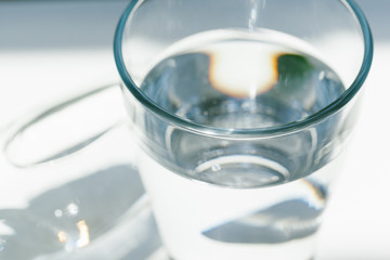 Glass of water with a bottle on table