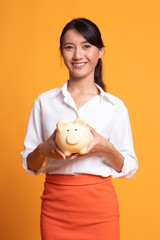 Fototapeta na wymiar Young Asian woman with a pig coin bank.