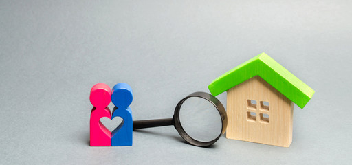 A loving couple is standing near a wooden house. The concept of finding a house or apartment for a...