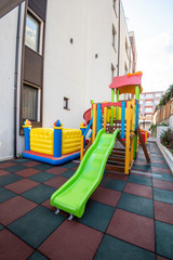 Fototapeta na wymiar Playground kid zone in a hotel rest territory. Modern children playground, Children playground on yard activities in park