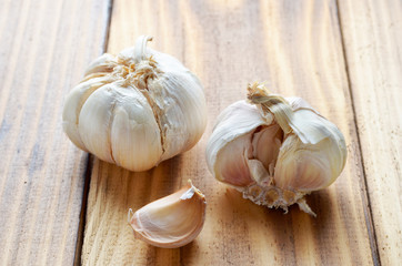 Organic garlic and cloves on the wood background.