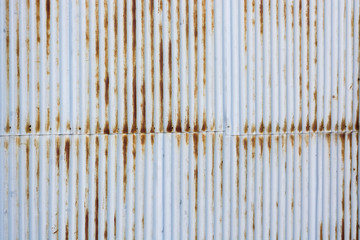 View on the background of an old decayed blue textured surface of a rusty wall or door with vertical lines
