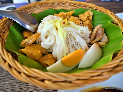 Myanmar Style national dish noodle (MoHinGa) in the basket. MoHinGa usually serve with boiled egg, fried peanut, fried fish and fish soup