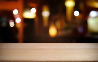 Empty dark wooden table in front of abstract blurred bokeh background of restaurant . can be used for display or montage your products.Mock up for space.