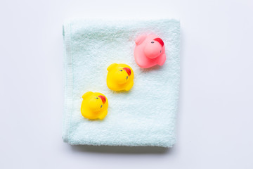 Pink and yellow duck  toys on soft green towel, white background. Kids bath concept.