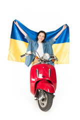 full length view of girl sitting on red scooter and holding Ukranian flag isolated on white