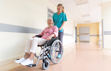 Senior woman in wheelchair with nurse in hospital