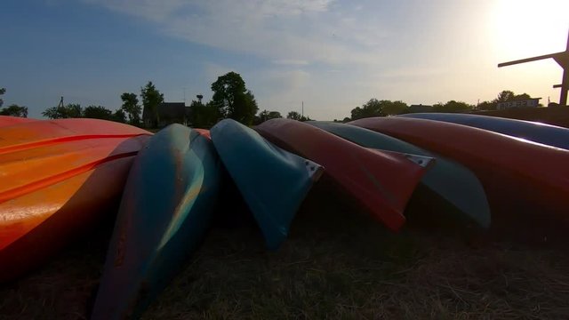 The sun dries multicoloed kayaks admitted to the queue. Slow motion