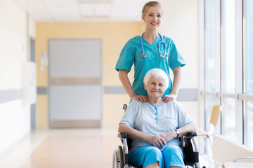 Senior woman in wheelchair with nurse in hospital