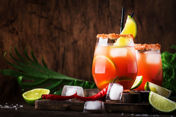 Michelada - Mexican alcoholic cocktail with beer, lime juice, tomato juice, spicy sauce and spices,...