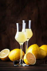 Limoncello, sweet Italian lemon liqueur, traditional strong alcoholic drink. Still life in vintage style, selective focus