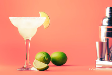 Lime margarita alcoholic cocktail with silver tequila, liqueur, lime juice, sugar syrup, salt and ice, festive trendy pink background, copy space - obrazy, fototapety, plakaty