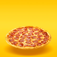 Creative layout of hot delicious pizza in flying on summer orange background. Pizza pepperoni...