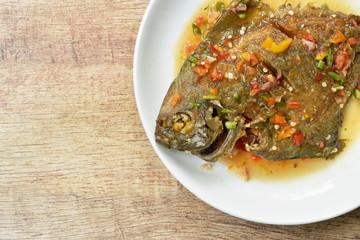 deep fried white pomfret dressing spicy sauce on plate