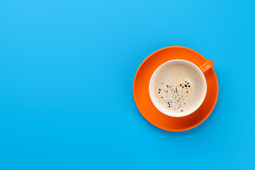Orange coffee cup over blue background