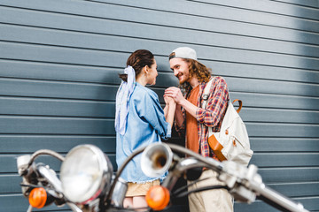 selective focus of young man and girl holding hands standing near wall