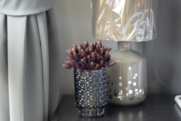 Purple artificial flowers in clear crystal glass