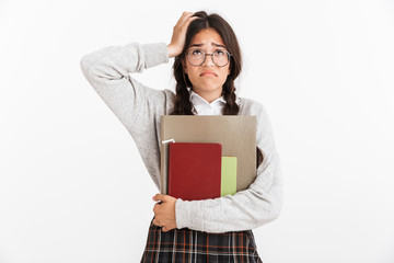 Photo closeup of tired teenage girl wearing eyeglasses stressing and grabbing her head while holding studying books