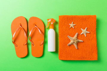 Top view of Beach flat lay accessories. sunscreen bottle with seashells, starfish, towel and...