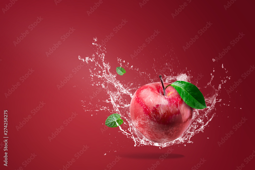 Wall mural water splashing on fresh red apple on red background - Wall murals