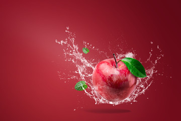 Water splashing on Fresh Red apple on red background
