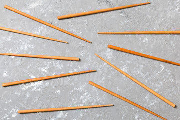 Many bamboo chopsticks on black cement stone background, top view with copy space. a lot of sushi sticks in the form of an ornament