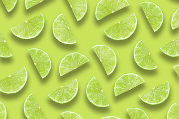 Fruit pattern of lime slices isolated on green background. Top view. Flat lay