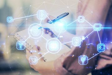 Social network theme hologram over hands taking notes background. Concept of global international people connect. Double exposure