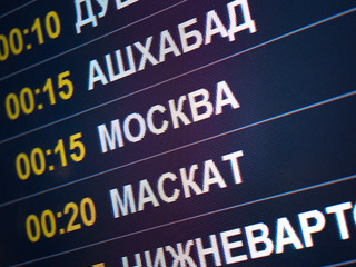 Electronic scoreboard flights and airlines. Destinations wrote in Russian language translate are: Ashgabat, Moscow, Muscat. Airport flight information arrival displayed on departure board, flight