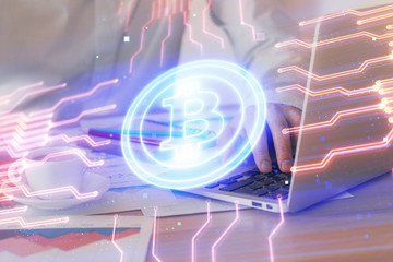 Crypto currency theme hologram with businessman working on computer on background. Concept of...