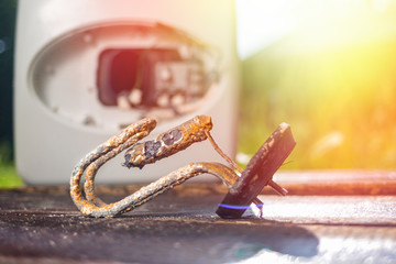 The water heating element damaged from corrosion lies on a wooden table next to the boiler. In the...