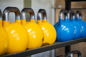 Naklejka na ściany i meble Heavy weight sets of kettlebell on iron racks at the gym used for functional fitness, high intensity CrossFit training, weight lifting or resistance training, concept for workout and healthy lifestyle
