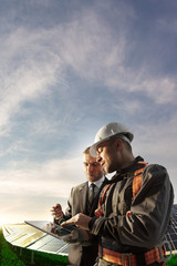 engineer and businessman planing new ecology project. they standing and looking in tablet