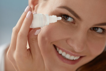 Eye drop. Woman applying lubricant eye drops in her eyes closeup