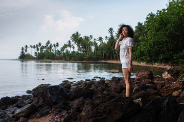 Fototapeta na wymiar Young asian woman on the coast of a tropical sea beach.