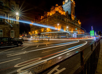 Fototapeta na wymiar Streets of Edinburgh, Scotland, at night with light trails of street traffic on Princes Street.