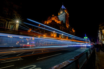 Fototapeta na wymiar Streets of Edinburgh, Scotland, at night with light trails of street traffic on Princes Street.