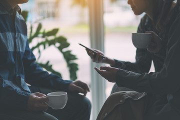People using phone, talking and drinking coffee together