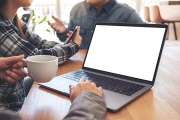 A woman using and touching on mockup laptop computer touchpad with colleagues in meeting