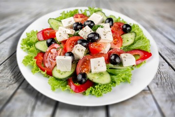 Greek salad with fresh vegetables on background
