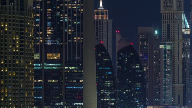 Aerial nighttime cityscape with illuminated architecture of Dubai downtown and financial center timelapse, United Arab Emirates. Tallest towers and skyscrapers with glowing windows