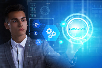 The concept of business, technology, the Internet and the network. A young entrepreneur working on a virtual screen of the future and sees the inscription: Blockchain